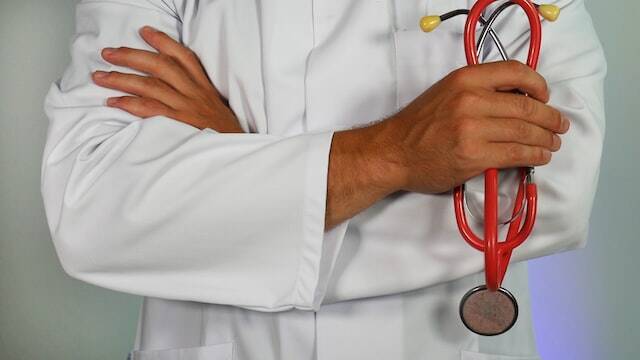 Médecin les bras croisés qui réfléchit à la solution pour soigner la maladie